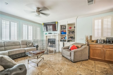 Living area with crown molding, a ceiling fan, and