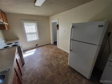 Kitchen with white appliances and a textured ceili