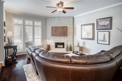 Living room featuring crown molding, ceiling fan, 