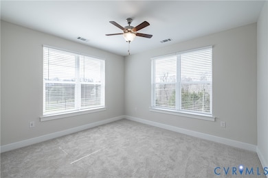 Empty room featuring carpet floors and a ceiling fan