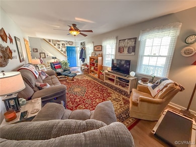 Living room with stairs, wood finished floors, and