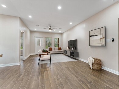 Bright and airy living room, where natural light floods the space, accentuating its warmth and inviting atmosphere. Large windows frame captivating views of the serene backyard