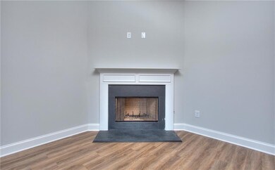 Detailed view of a fireplace with raised hearth and wood finished floors