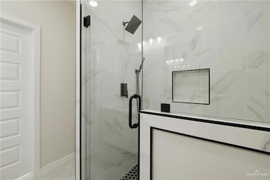 Full bath with a shower stall and baseboards