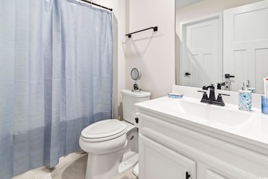 Full bath featuring a shower with curtain, toilet,