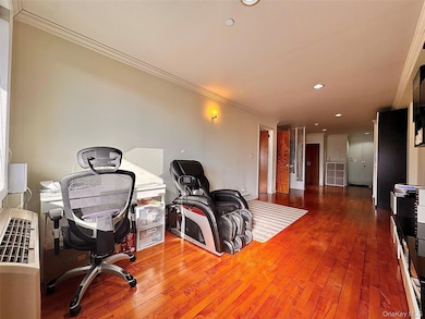 Office with hardwood / wood-style flooring and crown molding