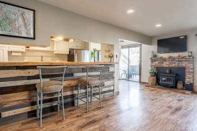Kitchen featuring light laminate flooring, a wood stove, freestanding refrigerator