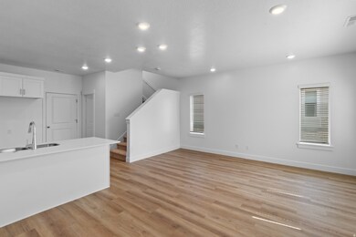 Unfurnished living room featuring stairway, light wood-style flooring, and recessed lighting