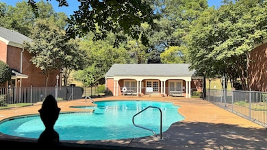View of pool with a patio area and view of scattered trees
