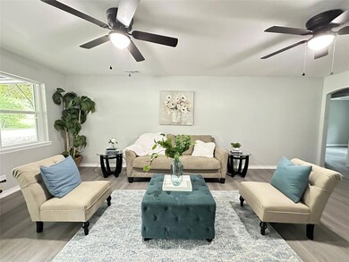 Living room featuring ceiling fan and hardwood / w