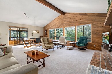 Elegant open concept living room, with a vaulted ceiling, exposed beam and a gorgeous brick & propane fireplace. A cozy and delightful living space!