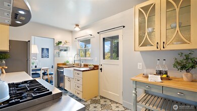 The kitchen is an absolute delight, blending vintage character with modern updates. Newer stainless appliances and a gas cooktop make cooking a joy, while glass-front cabinetry adds just the right touch of charm and personality to the space.
