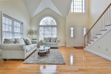 Living room with a high ceiling and light hardwood