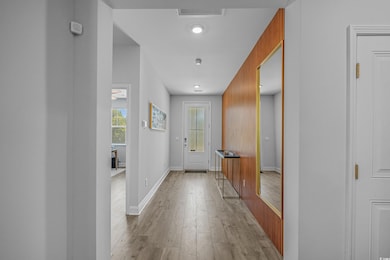 Doorway to outside featuring light wood-style floors and baseboards