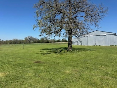 View of green lawn featuring barn and an outbuilding