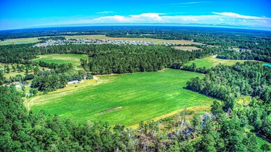 View of property location featuring a heavily wooded area and rural landscape