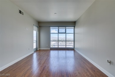 Empty room with dark wood-style floors and baseboa