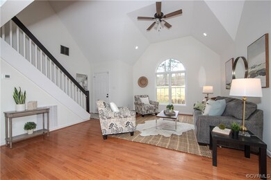 Living room with high vaulted ceiling, light hardwood / wood-style floors, and ceiling fan