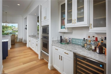 Kitchen with ornamental molding, white cabinetry, 