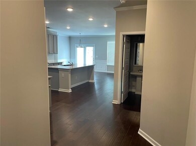 Kitchen with hanging light fixtures, dark hardwood / wood-style flooring, and a kitchen bar