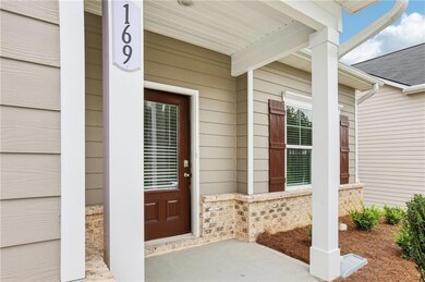 Doorway to property featuring covered porch and a shingled roof