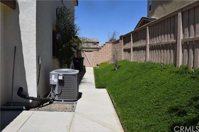 Both sides of backyard have concrete sidewalks. 