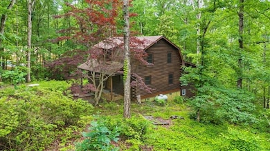 View of home's exterior featuring log exterior and a view of trees
