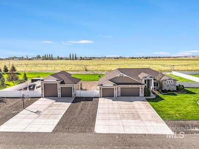 View of front of home with a rural view, a garage, stone siding, and concrete driveway
