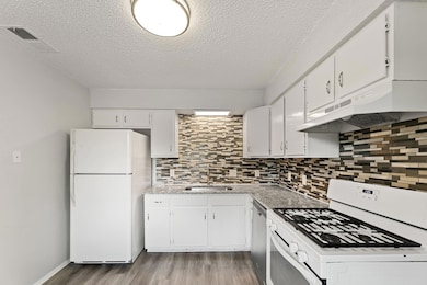 Kitchen featuring white appliances, a sink, under