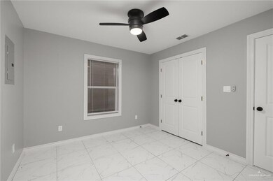 Unfurnished bedroom featuring light marble finish floors, electric panel, baseboards, and a closet