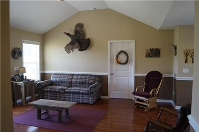 Large living room has chair rail, opens into dining area.