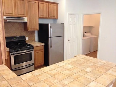 Kitchen featuring under cabinet range hood, appli