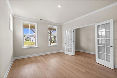 Unfurnished living room featuring light wood finished floors, a ceiling fan, crown molding, a chandelier, and stairway