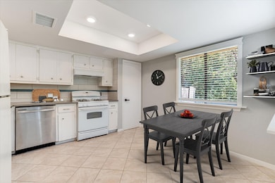 Kitchen with stainless steel dishwasher, white ga