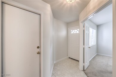 Foyer entrance featuring light colored carpet and