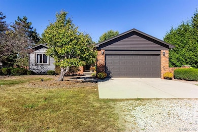 Ranch-style house featuring driveway, brick siding, and a front yard