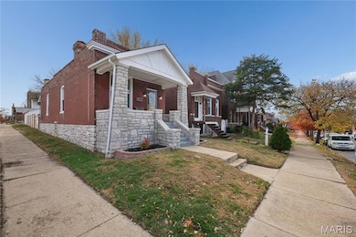 View of home's exterior featuring stone siding, a porch, a chimney, a yard, and brick siding