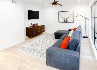 Living area featuring a ceiling fan, wood finishe