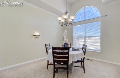 Carpeted dining room with baseboards, visible vent