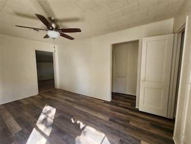 Empty room featuring dark hardwood / wood-style floors and ceiling fan