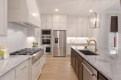 Beautiful kitchen with quartzite countertops, double oven, huge island and plenty of cabinets
