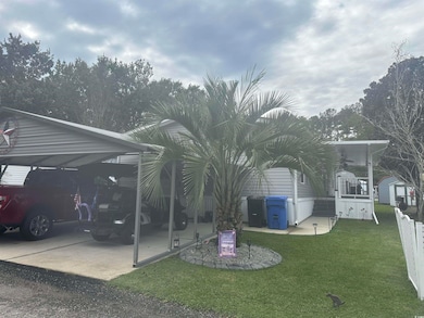 View of grassy yard with a carport