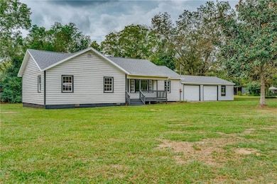 Back of house featuring crawl space, roof with shingles, and a yard