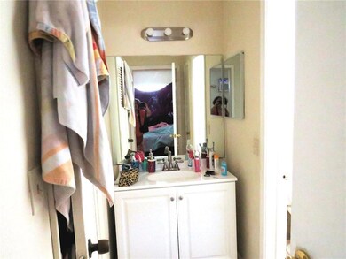 Vanity in efficiency next to walk in closet & bath