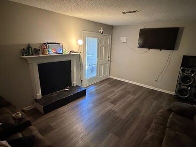 Living area featuring a textured ceiling and dark wood-style floors