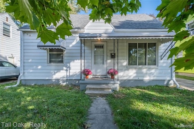 View of front of property featuring a shingled roof, a front lawn, and a porch