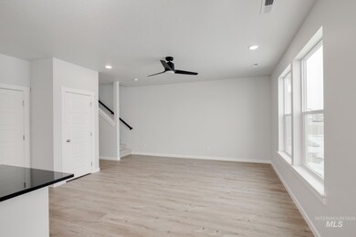 Unfurnished living room featuring light wood-style floors, recessed lighting, a ceiling fan, and stairway