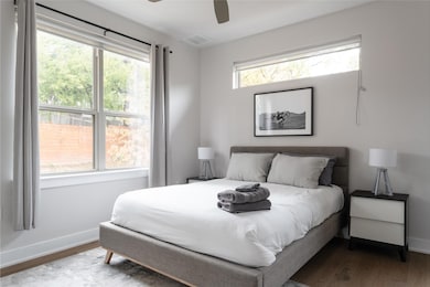 Bedroom with wood finished floors, baseboards, an