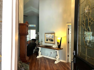 Foyer featuring dark wood-style floors, high vault