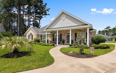 View of front of property with a porch, a front lawn, and brick siding